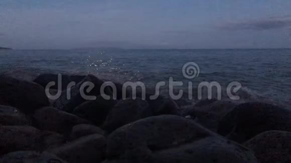 黎明时满月在尼霍岛上空从纳帕利海岸岩石附近的波里哈莱海滩夏威夷考艾岛视频的预览图