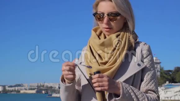 年轻迷人的女孩戴着太阳镜吹泡泡视频的预览图