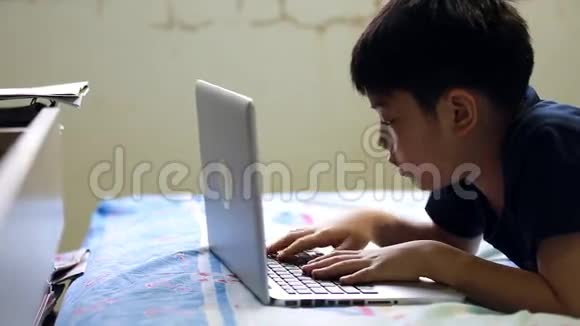 亚洲男孩在笔记本电脑上玩游戏视频的预览图