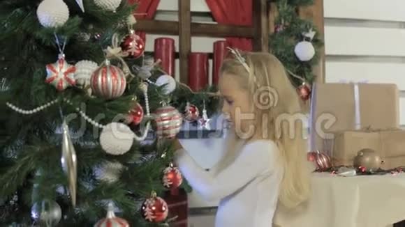 可爱的小女孩装饰圣诞树视频的预览图
