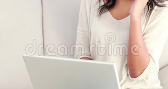 女人在沙发上用笔记本电脑打电话视频的预览图