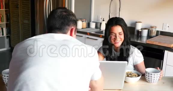 一对夫妇在吃早餐时用笔记本电脑视频的预览图