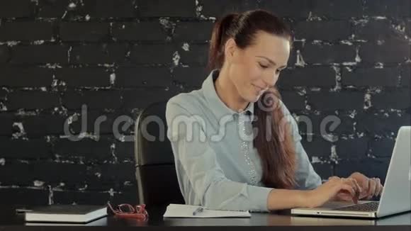 快乐女商人在笔记本电脑上工作视频的预览图