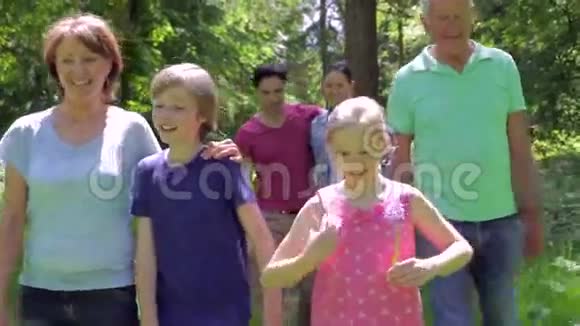 多代家庭一起沿木地径步行视频的预览图