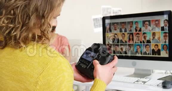 摄影师在数码相机上看照片视频的预览图