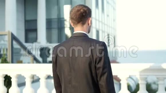 年轻成功的商人站在办公楼附近微笑视频的预览图