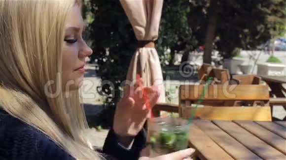 美丽的年轻女子在咖啡馆喝鸡尾酒视频的预览图