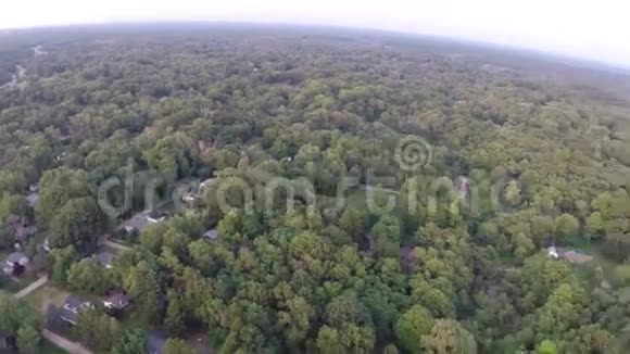 在五颜六色的树林里的房子上面飞翔视频的预览图