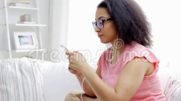 有智能手机和耳机的快乐非洲女人视频的预览图