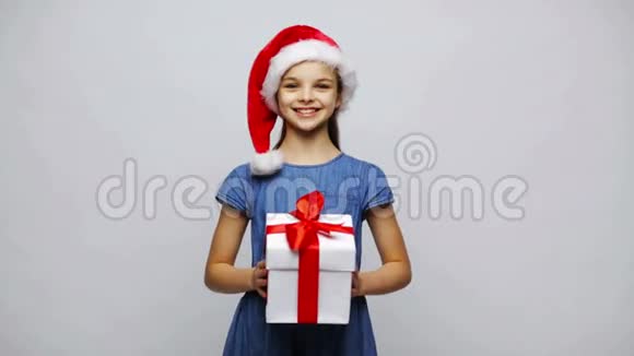 戴着礼物盒的圣诞帽快乐的微笑女孩视频的预览图