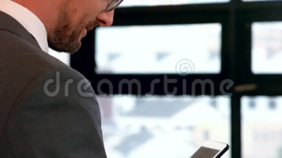 微笑的商人使用智能手机视频的预览图