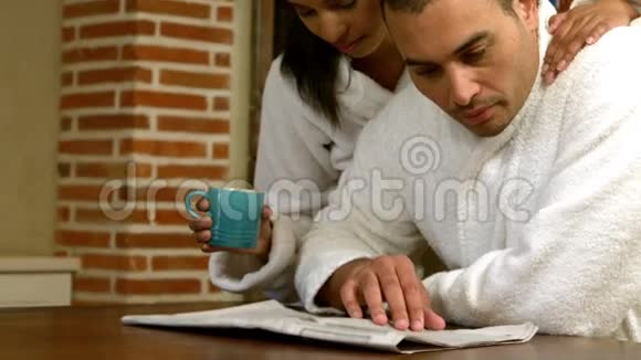 一对夫妇一边吃早餐一边看报纸视频的预览图