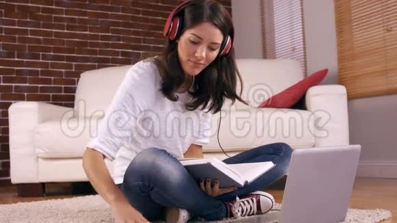 年轻漂亮的女人在地板上学习视频的预览图