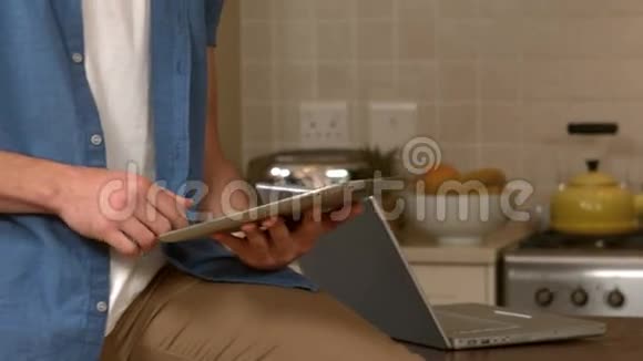 英俊的微笑男人用他的平板电脑视频的预览图