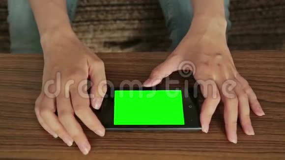 使用智能手机的女性使用绿色屏幕显示视频的预览图