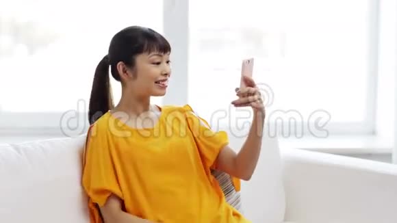 快乐的亚洲女人在智能手机上自拍视频的预览图