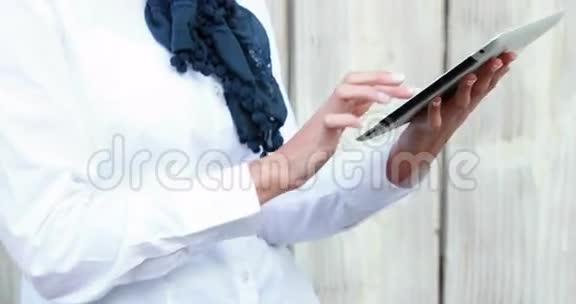 微笑的时髦女人用平板电脑视频的预览图