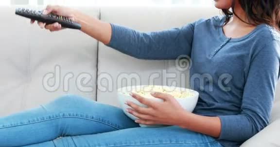 女人一边吃爆米花一边在沙发上放松视频的预览图