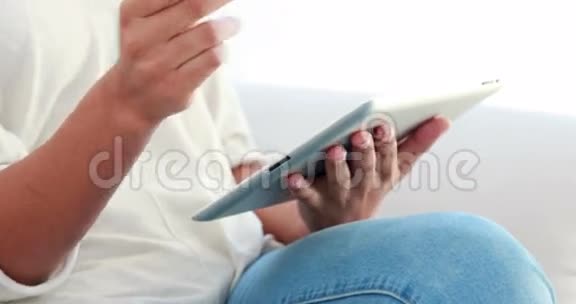 沙发上有数字平板电脑和信用卡的快乐女人视频的预览图