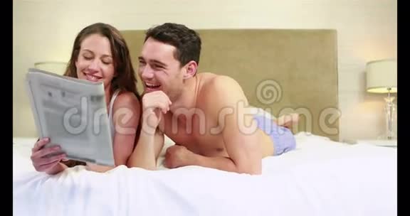 快乐的年轻夫妇一起读报纸视频的预览图