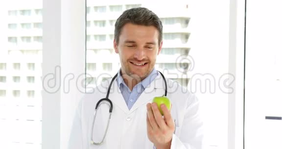 医生拿着一个绿苹果视频的预览图