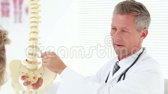 物理治疗师向病人解释脊柱模型视频的预览图