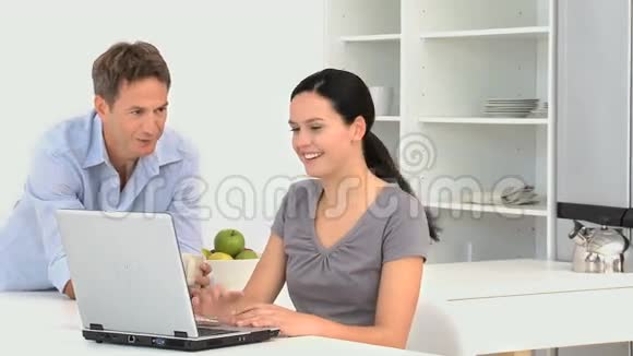 与丈夫一起在笔记本电脑上工作的女人视频的预览图