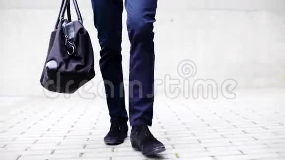 一个拿着袋子走在城市大街上的年轻人视频的预览图