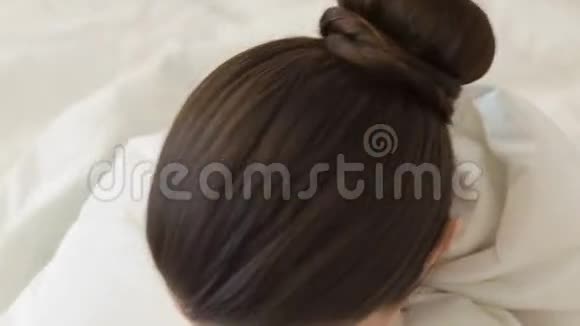 年轻微笑的女人坐在床上视频的预览图
