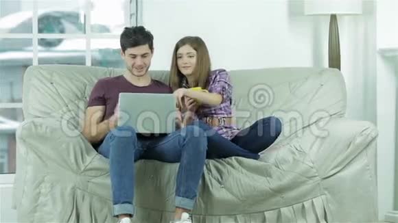 快乐的年轻人坐在沙发上视频的预览图
