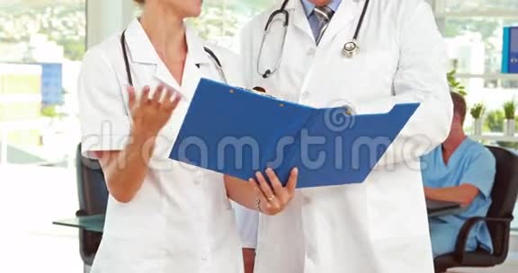 两位医生在医疗办公室看剪贴板视频的预览图