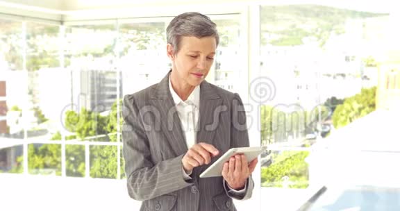 自信的女商人用平板电脑看相机视频的预览图