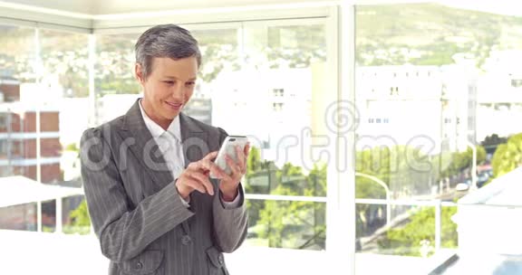 快乐的女商人用她的智能手机视频的预览图