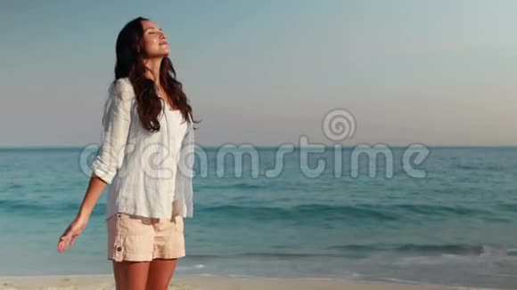 快乐的女人伸出双臂在海滩上视频的预览图