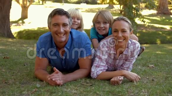 快乐的一家人对着公园里的摄像机微笑视频的预览图