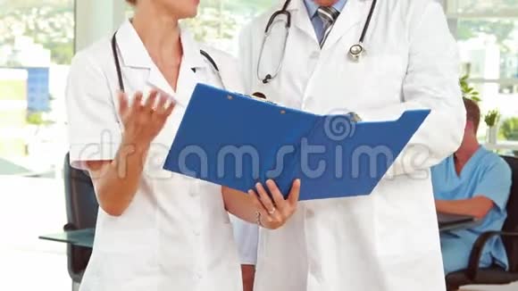 两位医生在医疗办公室看剪贴板视频的预览图