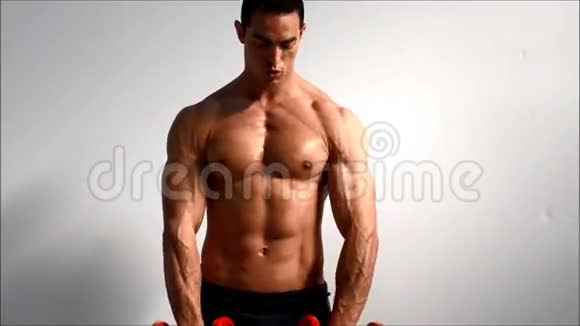 年轻英俊的男性健美运动员用哑铃训练肩膀视频的预览图