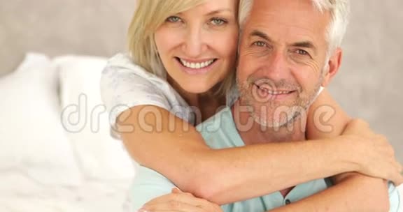 一对情侣在床上拥抱并微笑视频的预览图