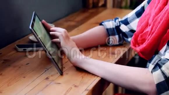 女人用平板电脑看窗户视频的预览图