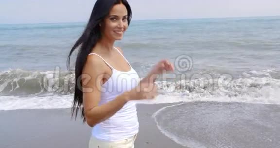 女人在沙滩上散步在镜头前微笑视频的预览图