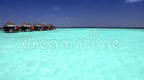 马尔代夫透明宁静的海水和热带天堂之上的房屋视频的预览图