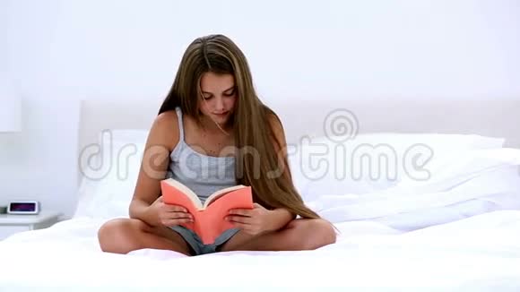 快乐的女孩在床上看书视频的预览图