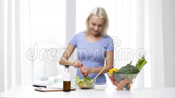 微笑的女人在家做蔬菜沙拉视频的预览图