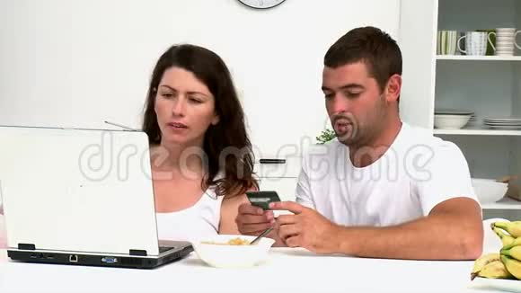 一对幸福的情侣用信用卡在网上购物视频的预览图