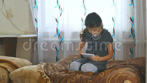 坐在平板电脑里玩的女孩视频的预览图
