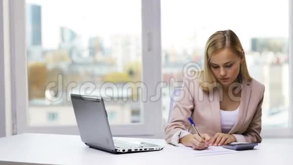 有笔记本电脑计算器和文件的女商人视频的预览图