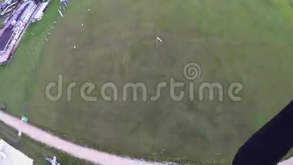 专业跳伞运动员降落在绿野上景观体育运动视频的预览图