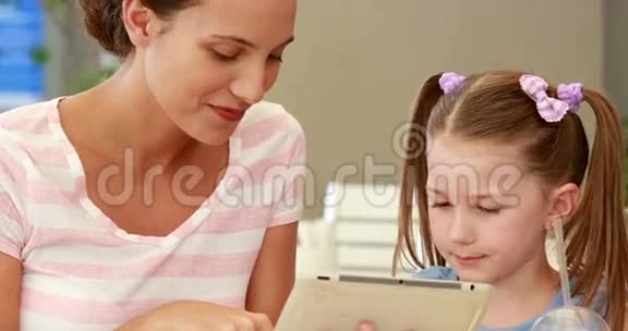 母亲和女儿一起使用平板电脑视频的预览图