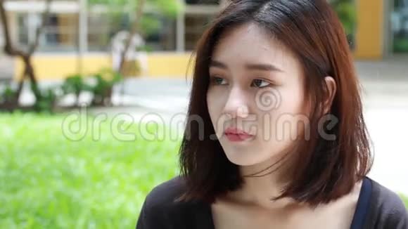 泰国成人学生大学漂亮女孩打智能手机的画像视频的预览图
