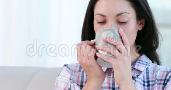 一个深褐色头发的女人在杯子里喝酒视频的预览图